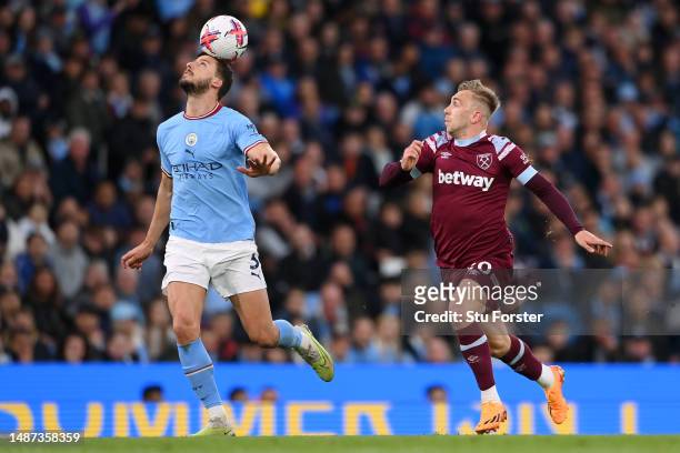 Ruben Dias of Manchester City battles for possession with Jarrod Bowen of West Ham United during the Premier League match between Manchester City and...