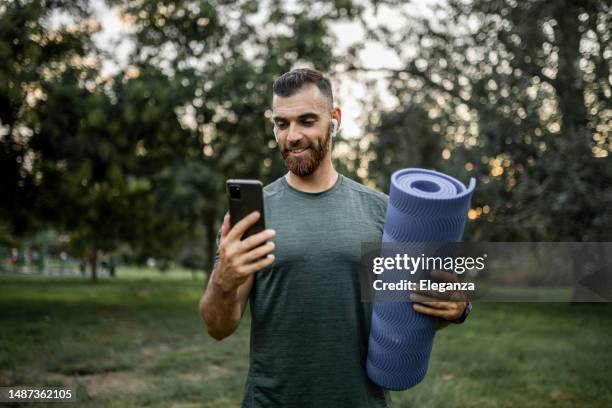 sporty young man using phone and preparing for workout - sprint phone stock pictures, royalty-free photos & images