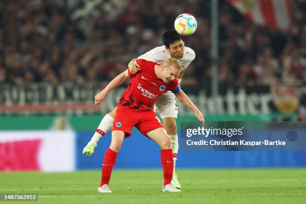 Wataru Endo of VfB Stuttgart heads the ball whilst under pressure from Sebastian Rode of Eintracht Frankfurt during the DFB Cup semifinal match...