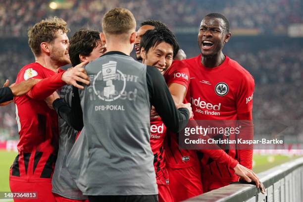 Daichi Kamada of Eintracht Frankfurt celebrates with teammates after scoring the team's second goal during the DFB Cup semifinal match between VfB...