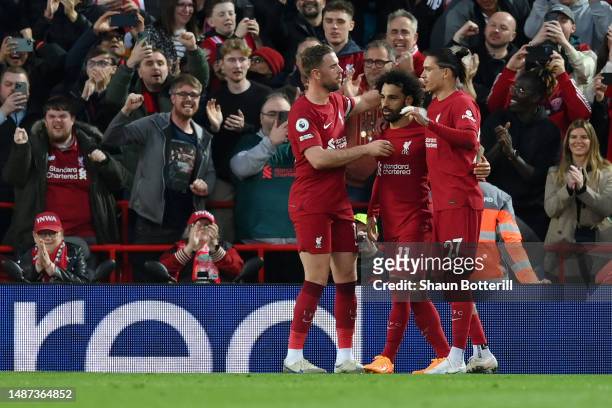 Mohamed Salah of Liverpool celebrates with teammates Jordan Henderson and Darwin Nunez after scoring the team's first goal from the penalty spot...