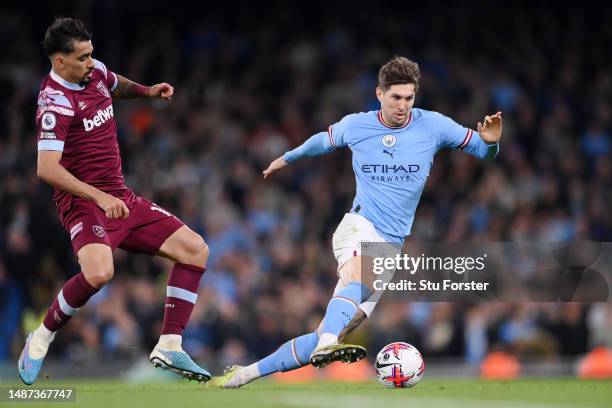 John Stones of Manchester City is challenged by Lucas Paqueta of West Ham United during the Premier League match between Manchester City and West Ham...