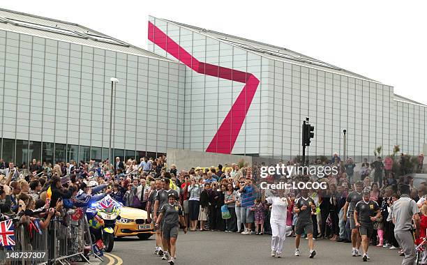 In this handout image provided by LOCOG, Former Olympic Swimmer Torchbearer 069 Karen Pickering carries the Olympic Flame on the Torch Relay leg...