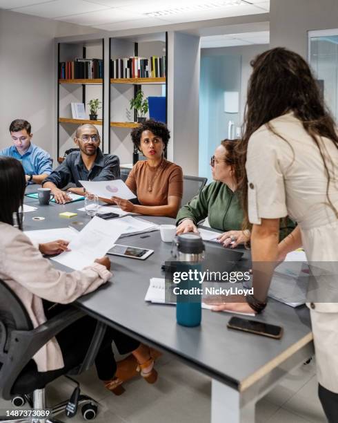 african woman sharing her ideas with team during boardroom meeting - staff meeting stock pictures, royalty-free photos & images