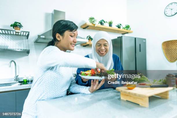 multi generation family making salad at home - ibnjaafar stock pictures, royalty-free photos & images