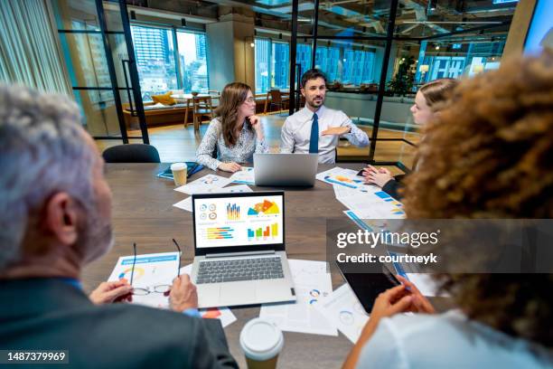 diverse group of people meeting and working at a board room table at a business presentation or seminar. - round table stock pictures, royalty-free photos & images