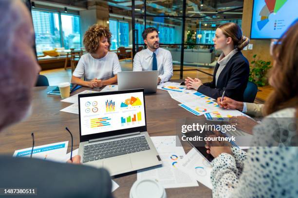diverse group of people meeting and working at a board room table at a business presentation or seminar. - round table discussion women stock pictures, royalty-free photos & images