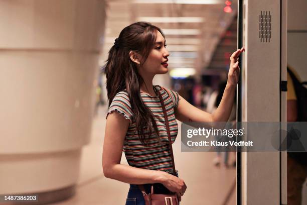 woman using kiosk at subway station - no pants subway stock pictures, royalty-free photos & images