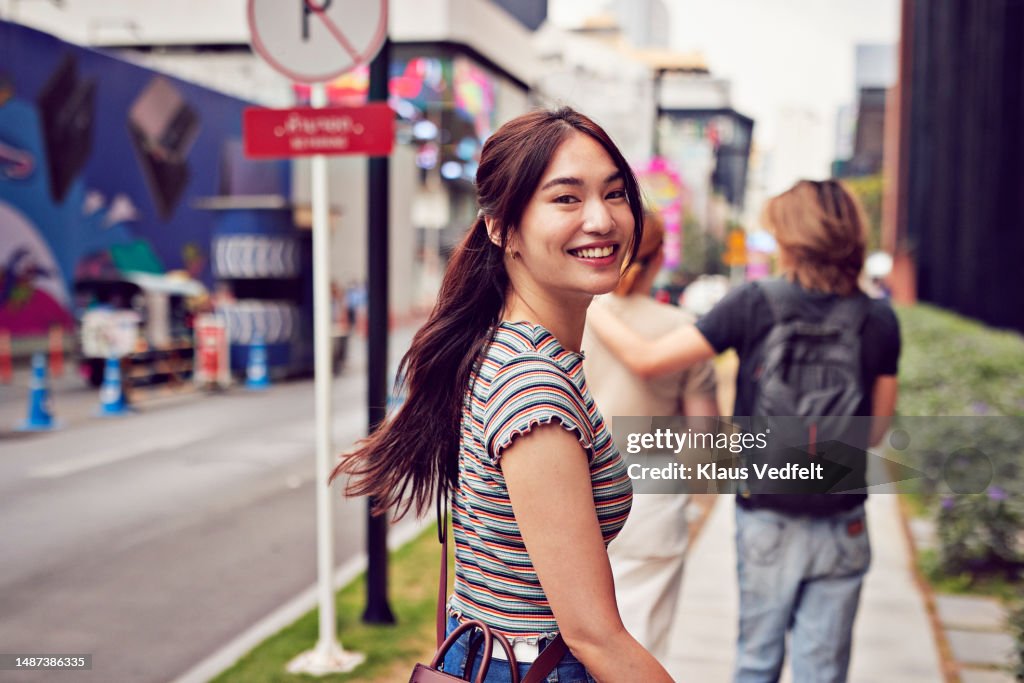 Happy young woman looking over shoulder