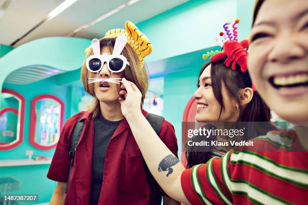 man wearing bunny sunglasses in store - whisker fotografías e imágenes de stock