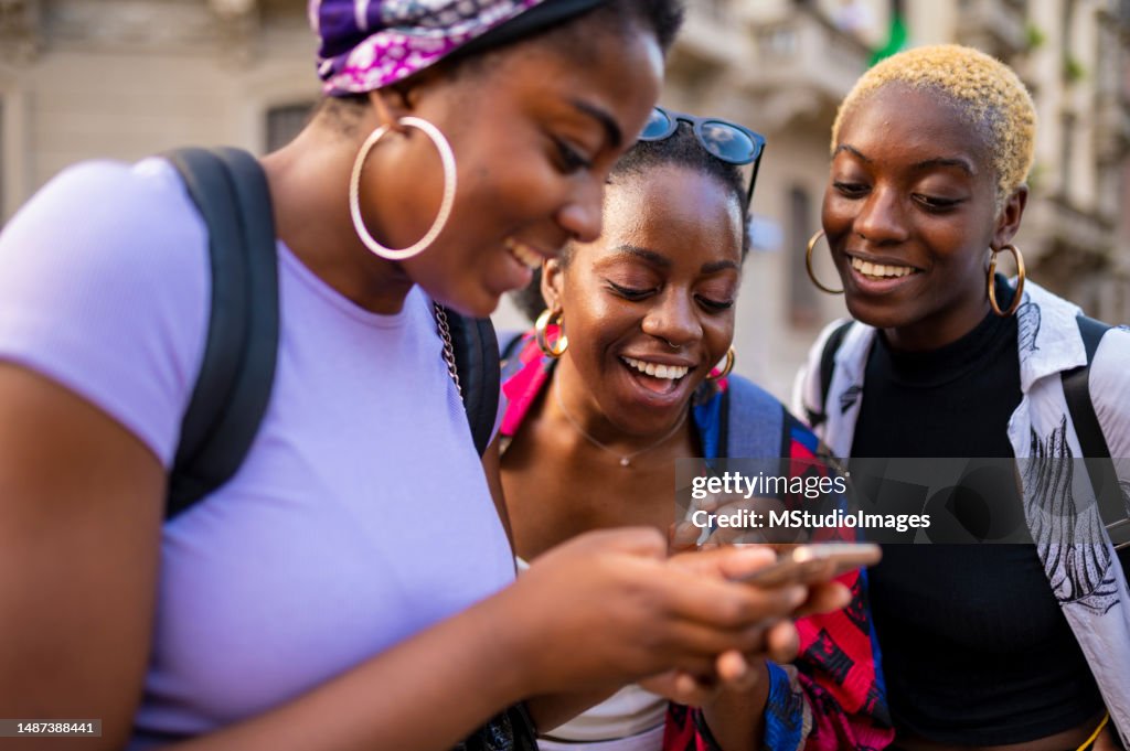 Three Smiling Women Using Mobile Phone High-Res Stock Photo - Getty Images