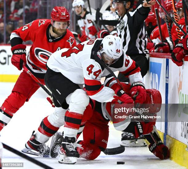 Miles Wood of the New Jersey Devils battles Jesper Fast of the Carolina Hurricanes for the puck during the second period in Game One of the Second...