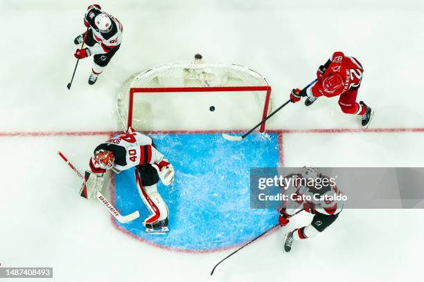 Jesperi Kotkaniemi of the Carolina Hurricanes scores a goal against Akira Schmid of the New Jersey Devils during the second period in Game One of the...