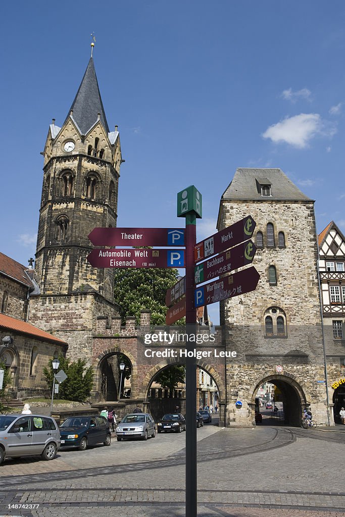 Tourist information signs in German and Japanese language with Nikolaikirche church and town gate at Karlsplatz square.