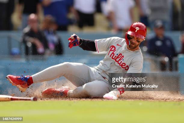 Bryce Harper of the Philadelphia Phillies slides at home plate to tie the game 6-6 during the ninth inning against the Los Angeles Dodgers at Dodger...