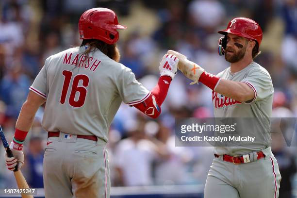 Brandon Marsh and Bryce Harper of the Philadelphia Phillies react after tying the game 6-6 during the ninth inning against the Los Angeles Dodgers at...