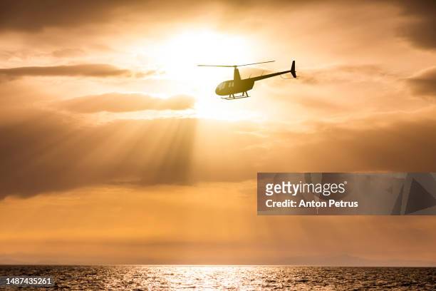 helicopter on the background of the sunset sky - beach rescue aerial stock pictures, royalty-free photos & images