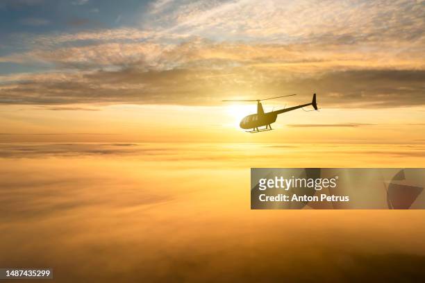 helicopter on the background of the sunset sky - air taxi stock pictures, royalty-free photos & images