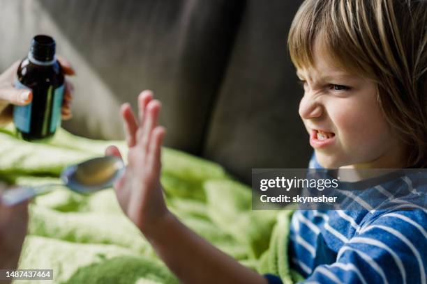 angry little boy refusing to drink medical syrup at home. - refusing stock pictures, royalty-free photos & images