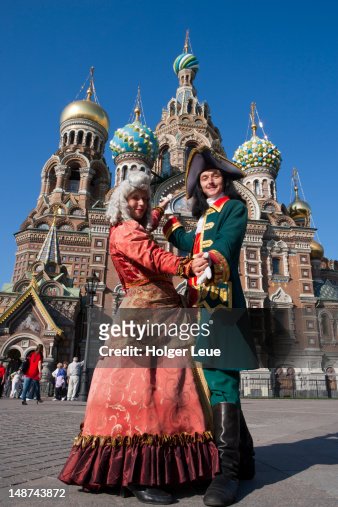 Couple in historic costumes of Empress and Tsar pose in front of Church of the Savior on Spilled Blood (Church of the Resurrection).