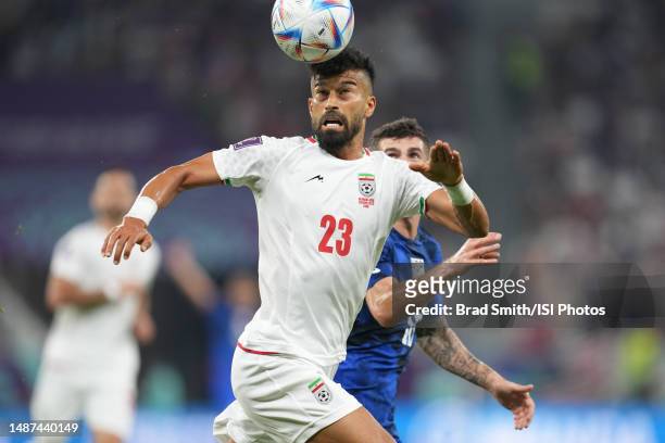 Ramin Rezaeian ofIR Iran battles for the ball with Christian Pulisic of the United States during a FIFA World Cup Qatar 2022 Group B match between IR...