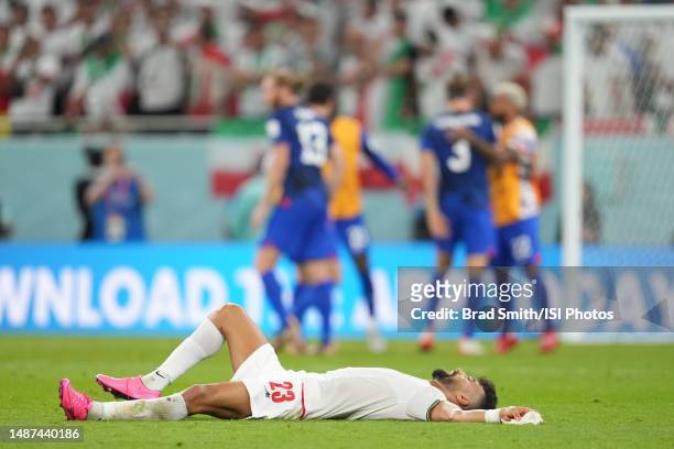 Ramin Rezaeian ofIR Iran lays on the field after a FIFA World Cup Qatar 2022 Group B match between IR Iran and USMNT at Al Thumama Stadium on...