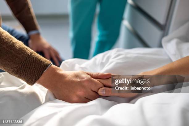 paciente sosteniendo la mano de su marido en el hospital. - unconscious fotografías e imágenes de stock