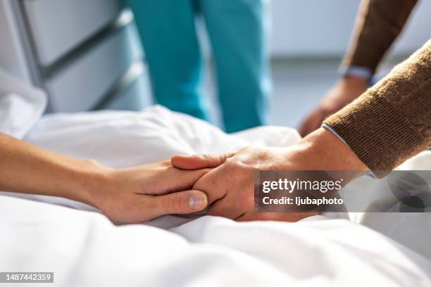 woman laying in a bed and her husband sitting next to her - lymphoma stock pictures, royalty-free photos & images