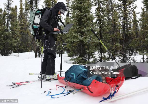SnowEx researcher Dr. Kelly Gleason works during testing for snow albedo in a section of boreal forest during the melt season on May 3, 2023 near...