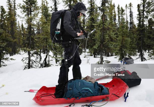 SnowEx researcher Dr. Kelly Gleason works during testing for snow albedo in a section of boreal forest during the melt season on May 3, 2023 near...