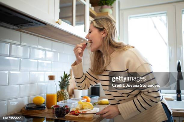 女性の健康的なフルーツサラダの準備 - 良い姿勢 ストックフォトと画像