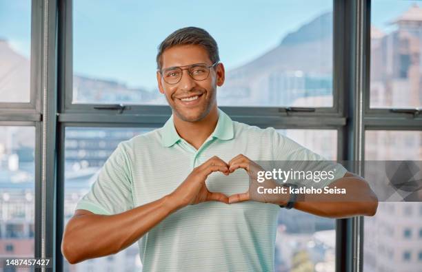 portrait, heart hands and smile of man in home for affection, care and romance. hand gesture, happiness and person with love emoji, sign or symbol for kindness, empathy and commitment or valentines. - portrait afrika kind stock pictures, royalty-free photos & images