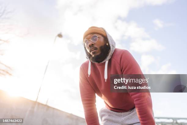 leaning forward, taking a breath after jogging - hand on knee stock pictures, royalty-free photos & images