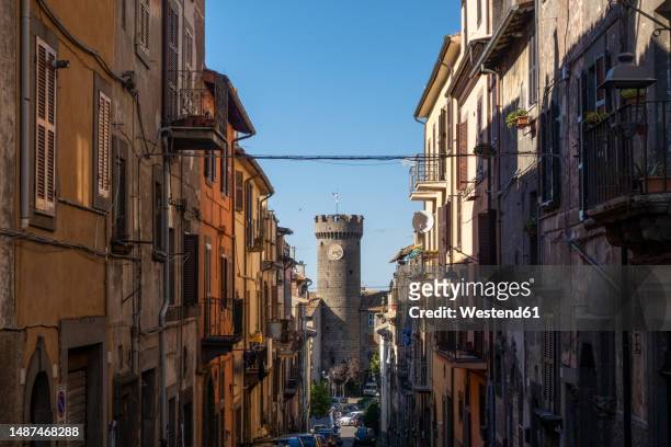 italy, lazio, viterbo, rows of houses with tower of palazzo ducale o delle logge in background - provinz viterbo stock-fotos und bilder
