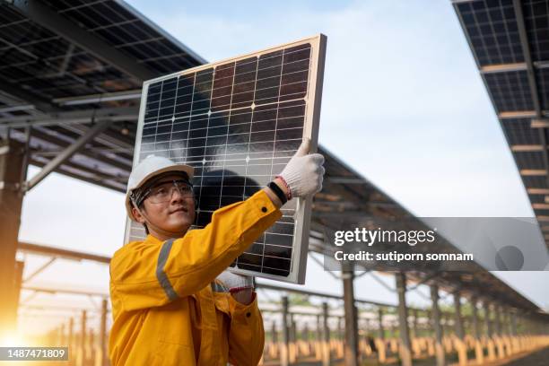the solar technician carrying solar panels in the solar farm construction - lunar module stock pictures, royalty-free photos & images