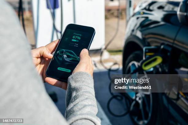 man checking car charging status on smart phone - electric car display stock pictures, royalty-free photos & images