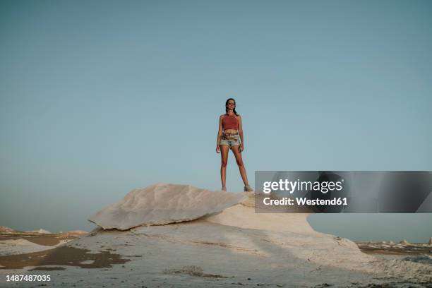 woman standing on rock at sunset in desert - farafra stock pictures, royalty-free photos & images