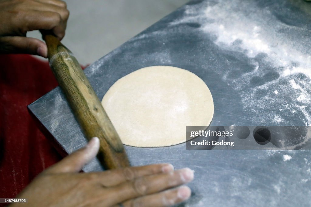 Hindu man preparing indian flat bread Chapathi from wheat dough. Shiva hindu temple. Dubai. United Arab Emirates. Dubai. United Arab Emirates