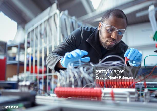 engineer assembling components in electronics factory - engineering stockfoto's en -beelden