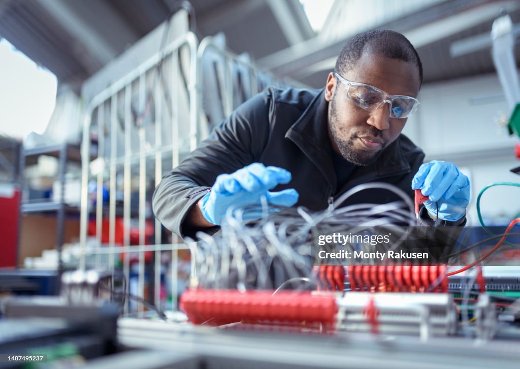 Engineer assembling components in electronics factory