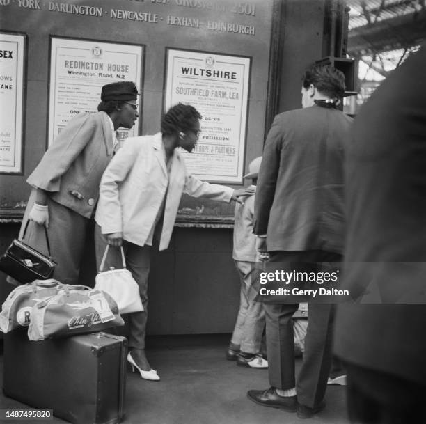 West Indian woman places her hand on the shoulder of a young boy on their arrival at Waterloo Station in London, England, 30th June 1962. The group...