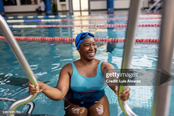 smiling woman swimmer entering pool - female bathing suits fotografías e imágenes de stock
