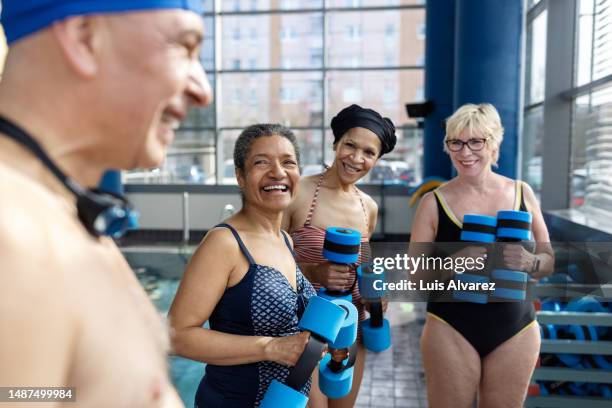 multiracial active seniors taking a break from exercising at workout class - woman swimsuit happy normal stock pictures, royalty-free photos & images