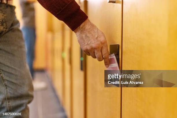 close-up of hand opening change room locker with keycard - 余暇施設 ストックフォトと画像