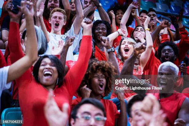 enthusiastic audience raise their arms up to cheer in celebration of their home soccer team - hurra bildbanksfoton och bilder