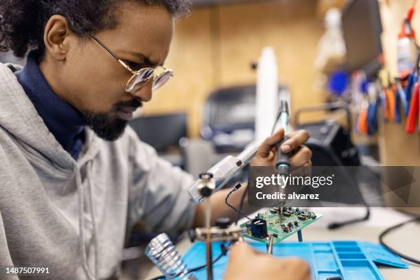 young man preparing circuit board at workshop - resistor stock pictures, royalty-free photos & images