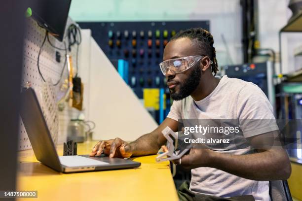 uomo africano che controlla il programmatore di stampa 3d che lavora al laboratorio spaziale dei produttori - stampante 3d foto e immagini stock