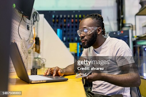 African man checking the 3D printing programer working at makers space lab