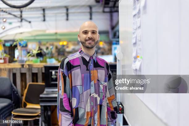 portrait of confident entrepreneur standing by whiteboard at creative office - founder stock pictures, royalty-free photos & images