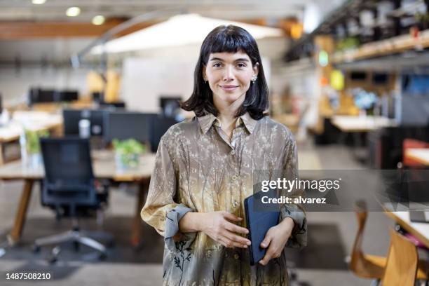 porträt einer selbstbewussten jungen frau, die im makers space steht - designberuf stock-fotos und bilder